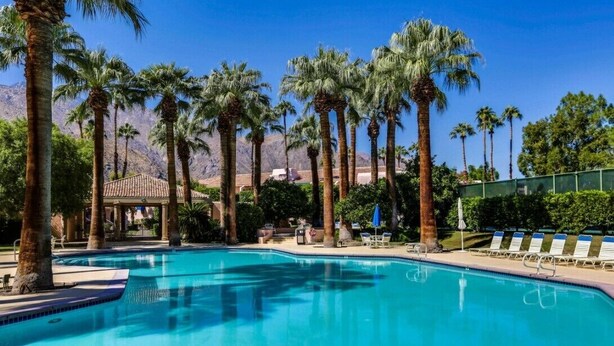 A swimming pool surrounded by palm trees and a mountain backdrop. - Three Pools. Mountain Views. Just Blocks from vibrant downtown nightlife! (Palm Springs)