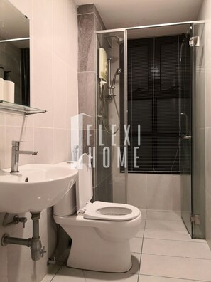 A modern bathroom with a glass shower enclosure, a white sink, and a toilet. - Eclipse Residency, Cyberjaya by Flexihome MY (Cyberjaya)