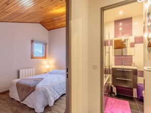 A bedroom with a bed, a window, a bedside lamp, and a view of the mountains. - Duplex 38m², 5 pers, 2 TVs, balcony, ski locker (La Plagne-Tarentaise)