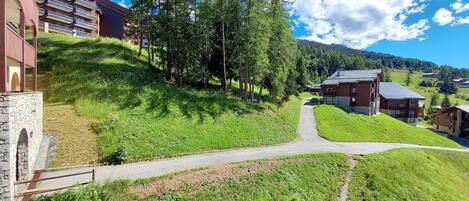 A hillside hotel with a stone pathway leading to the entrance.