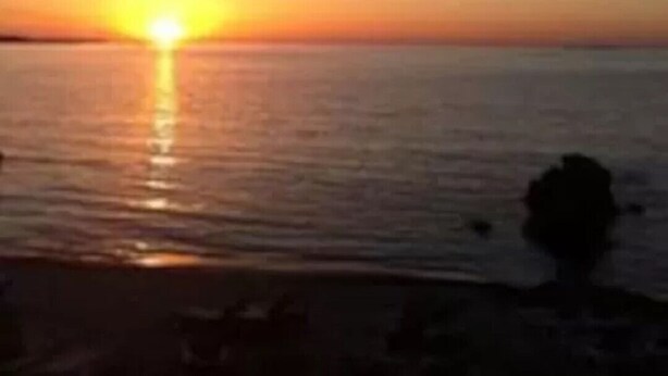 A sunset over a calm sea with a silhouette of a person in the foreground. - BRILOC Apartment (48 m² - 48 sq ft - ) (Ajaccio)