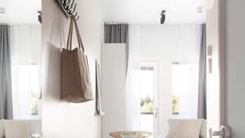 Une pièce moderne avec une table en bois, des chaises, un canapé et une grande fenêtre avec des rideaux.