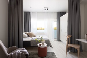 Escritorio, cortinas blackout y tabla de planchar con plancha