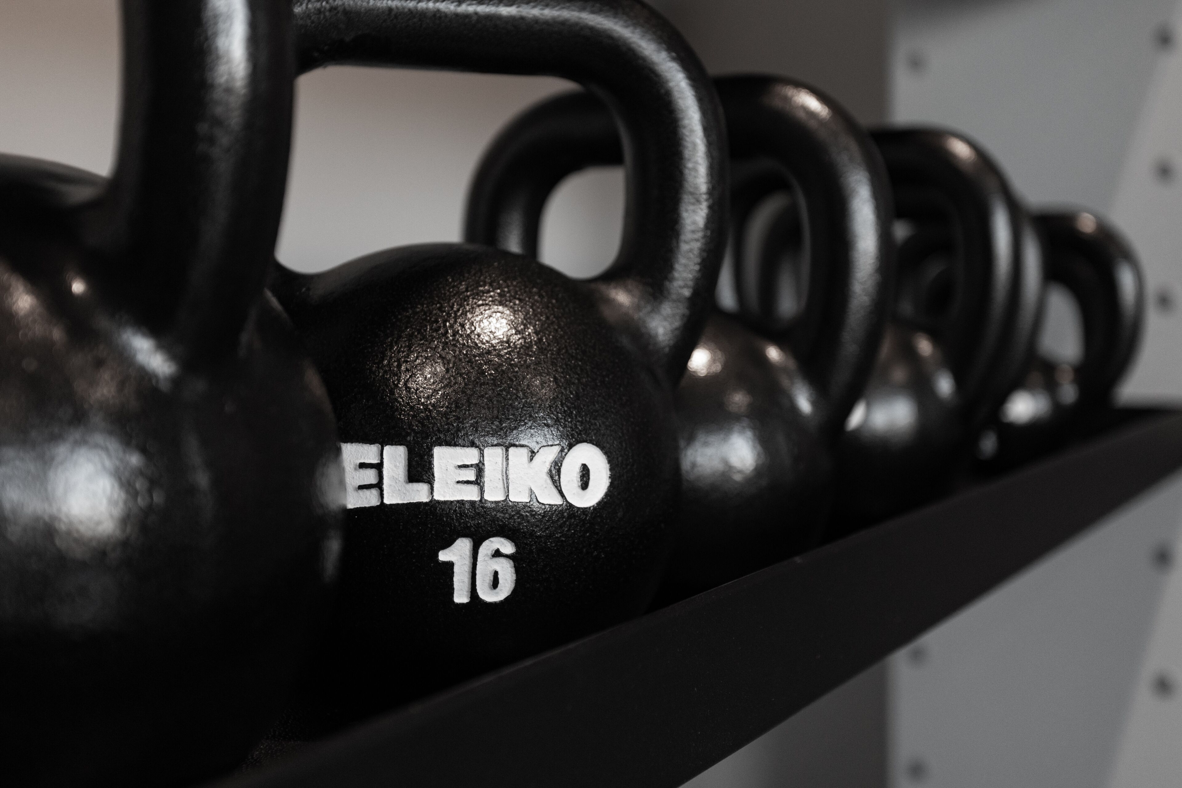 Rivi mustia kahvakuulia, joiden merkki on ELEIKO ja paino 16.