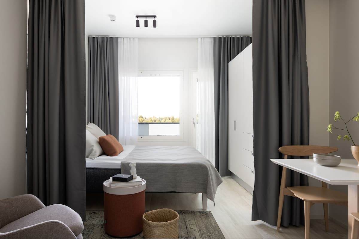 Ein modernes Hotelzimmer mit Bett, Schreibtisch und Blick ins Freie.