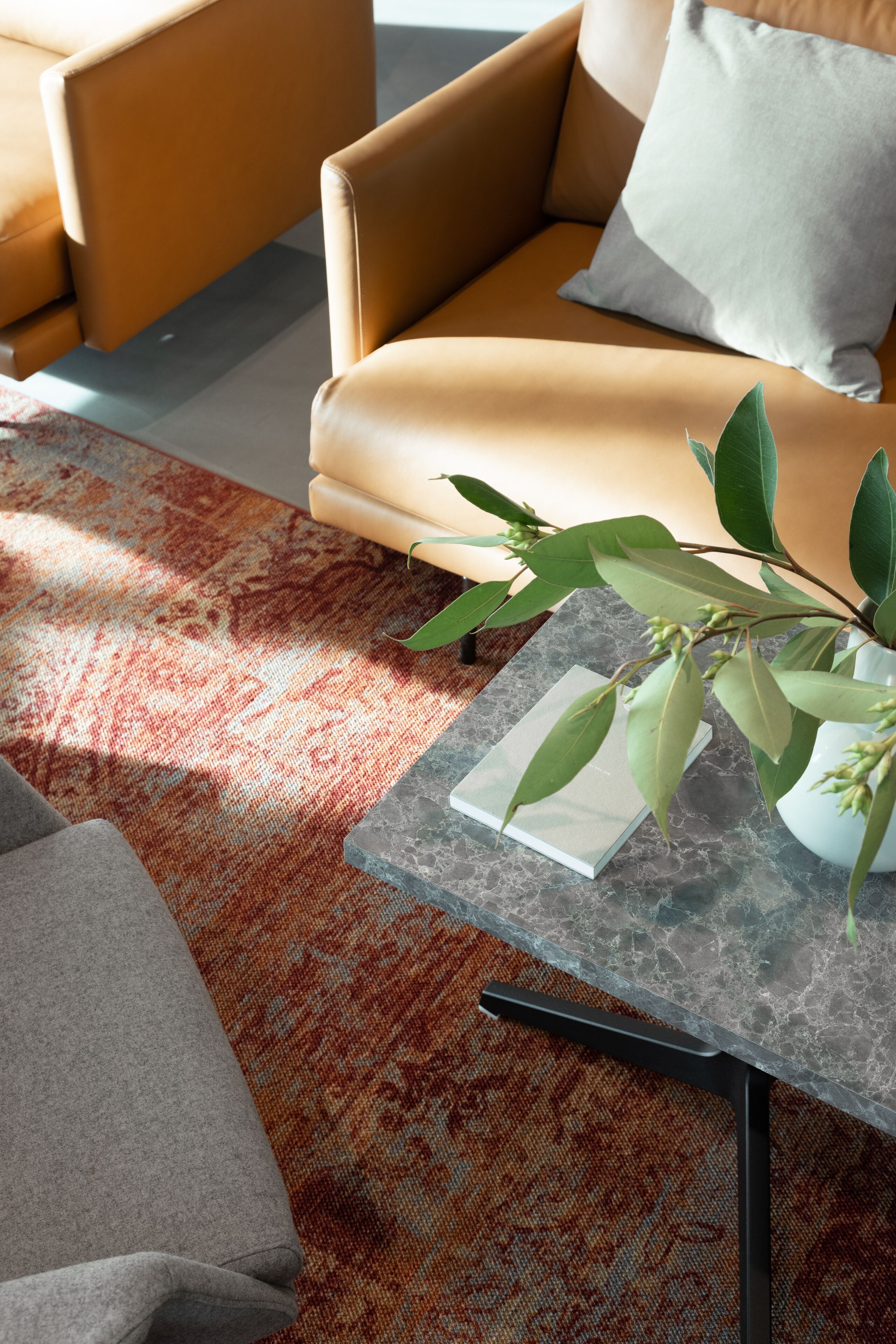A modern living room with a sofa, a coffee table, and a patterned rug.