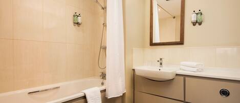A modern bathroom with a bathtub, a sink, and a toilet.