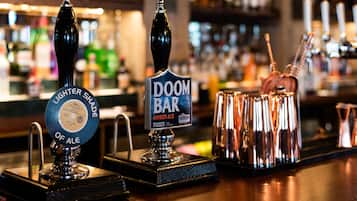 A bar with two tap handles, one labeled 'Lighter Shade of Ale' and the other 'Doom Bar Amber Ale'.