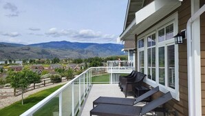 A balcony with outdoor furniture, a glass railing, and a view of distant mountains. - View - Beautiful home - 2 kitchens #198 (Osoyoos)