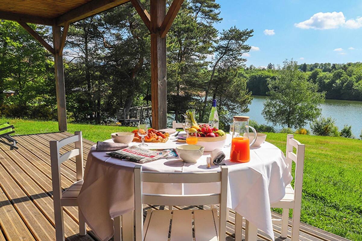 Una mesa dispuesta al aire libre con comida, bebida y una revista.
