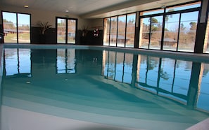 An indoor swimming pool with clear reflections, large windows, and potted plants. - Le Domaine des Monedieres (Meyrignac-l'Eglise)