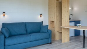 A room with a blue sofa, a wooden cabinet, and a small table.