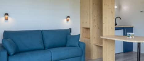 A room with a blue sofa, a wooden cabinet, and a small table.