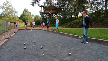 Una cancha de shuffleboard con jugadores y una mesa de juego.