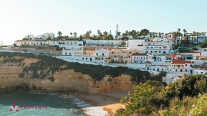 A coastal town with white buildings, a beach, and a cliff. - Villa Marianna do Sol with private pool for 10 people (Porches)