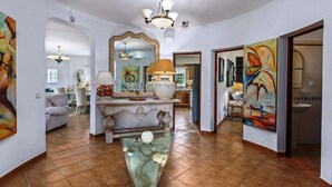 A spacious hallway with a tiled floor, a central console table, and a large mirror. There are paintings on the walls and a chandelier above the console table. - Villa Marianna do Sol with private pool for 10 people (Porches)