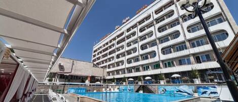 Una piscina al aire libre, camas de piscina gratis, sombrillas
