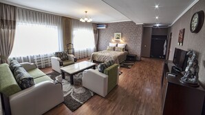 A modern living room with a sofa, a coffee table, a TV, and a bed. - OshNuru (Osh)