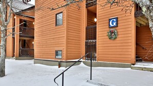 Un edificio de madera con un balcón y un letrero con la letra 'G'.