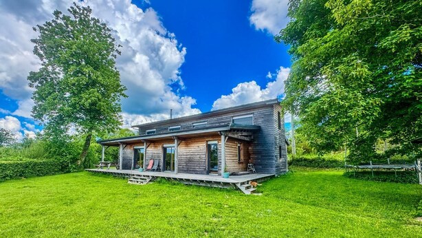 A modern wooden house with a covered porch, large windows, and a well-maintained lawn. - Domaine Taureau, Morvan Regional Nature Park (Saint-Brisson)