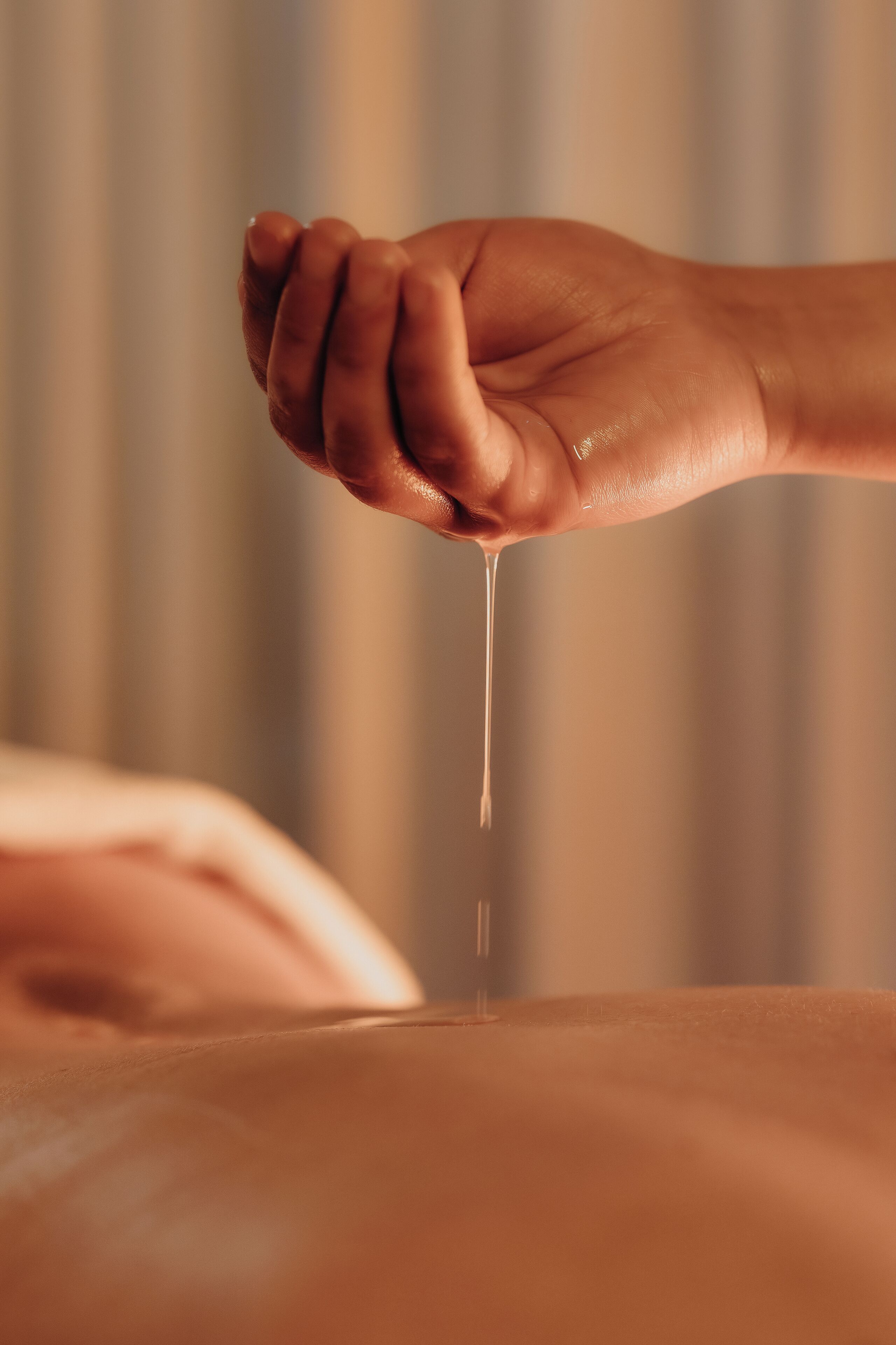 A close-up of a hand holding a dropper, likely dispensing a liquid.