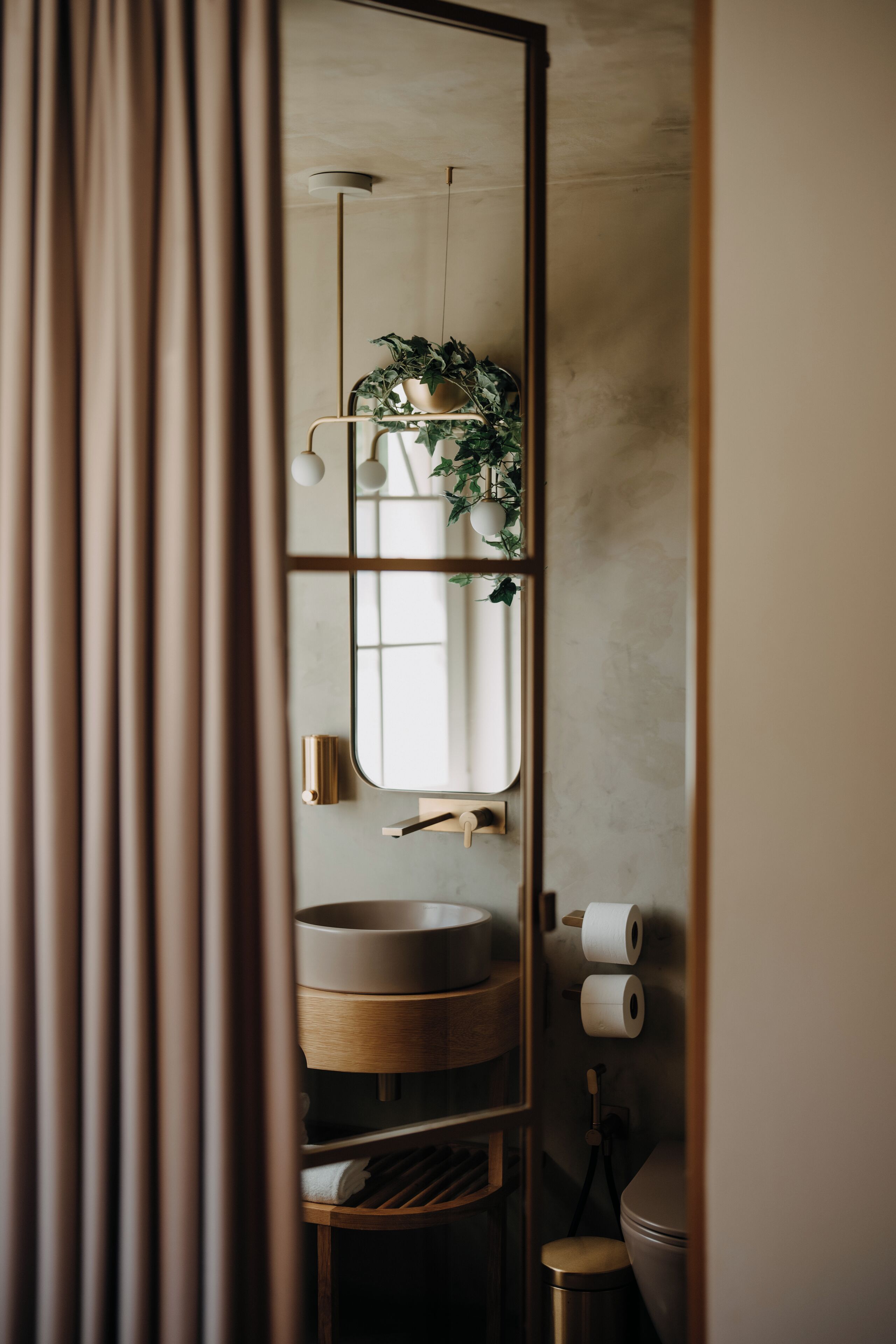 Un bagno con un mobile contenitore in legno, uno specchio e un water.