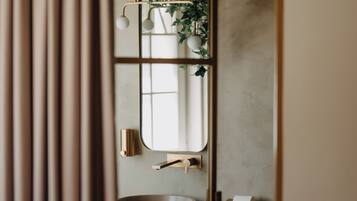 Un bagno con un mobile contenitore in legno, uno specchio e un water.