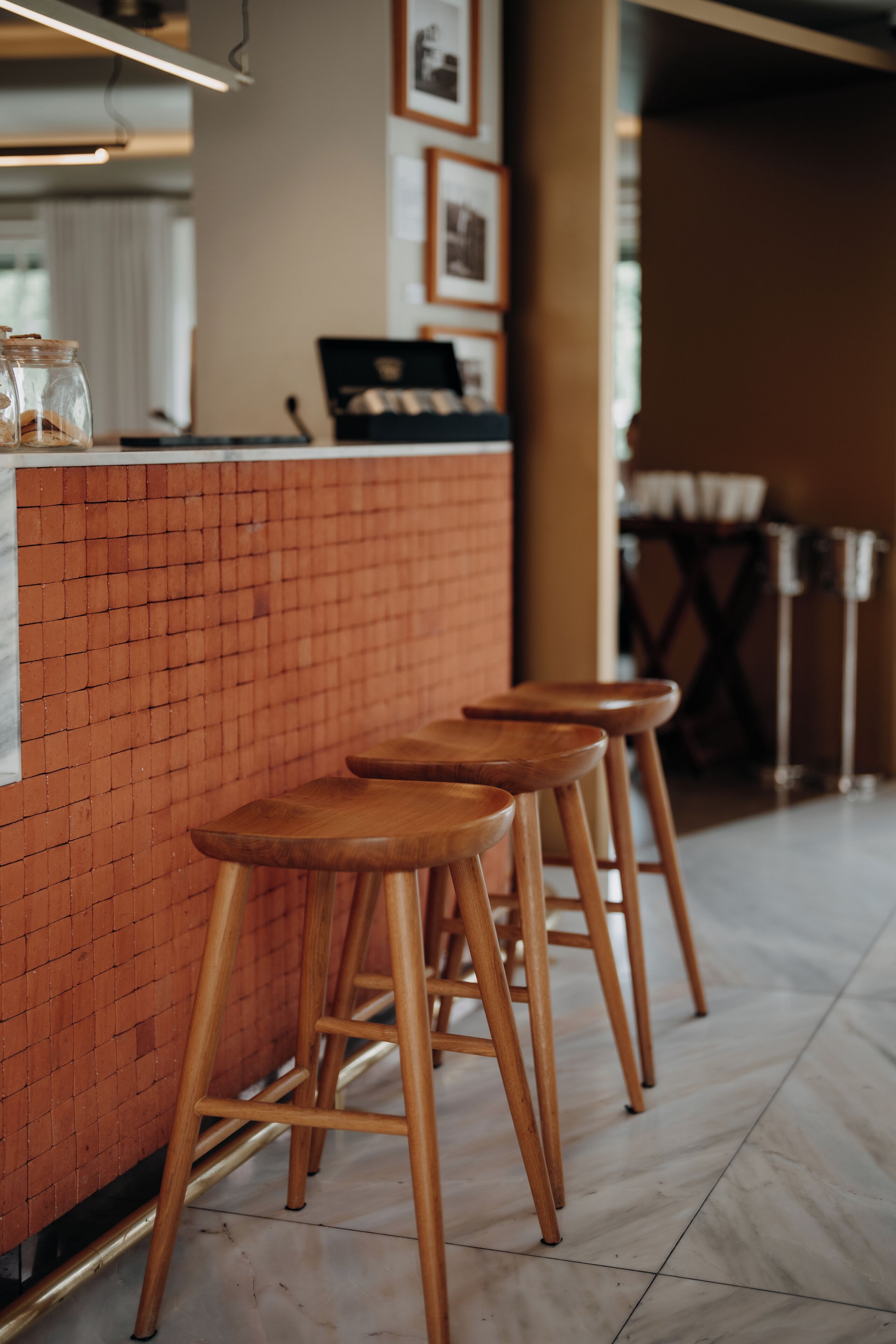 A bar area with wooden stools and a tiled counter.