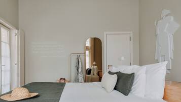 Un dormitorio con una cama, almohadas, un sombrero, un espejo y una pared con texto.