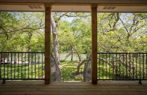 A covered outdoor area with a view of a park and a lake.