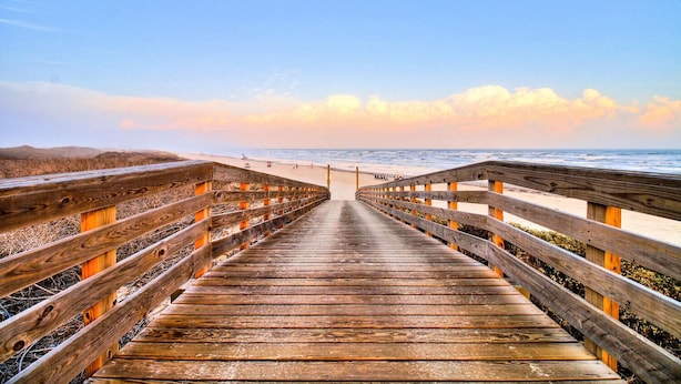 A wooden boardwalk leading to a beach with a clear sky. - This spacious home has sophisticated beach decor, adding to the welcoming feel t (Port Aransas)