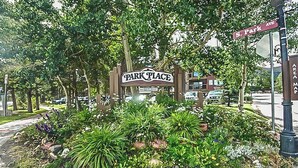 Un panneau indiquant « Park Place », avec un espace paysager aménagé devant, comprenant des rochers et des plantes.