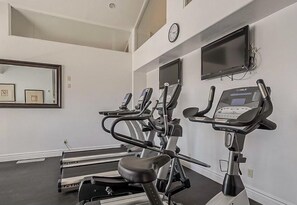 A gym with treadmills and elliptical machines, a clock, and framed pictures on the wall. - Tastefully Decorated, Perfect Scottsdale Location condo w/ Pool, Spa, Gym! (Scottsdale)