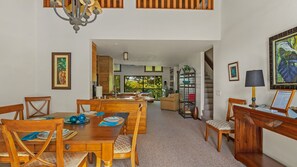 A spacious dining area with wooden furniture, a chandelier, and a view of the outdoors.