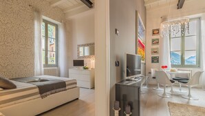 A modern bedroom with a bed, a desk, and a dining area. - Il Diamante del Lago (Varenna)
