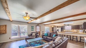 A spacious living room with leather sofas, a coffee table, and a dining area with a bar. - Hondo's River Haus Rr 1300 4 Bedroom Home by RedAwning (New Braunfels)