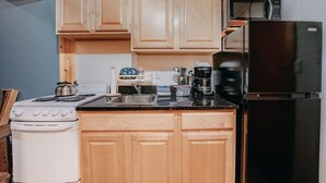 A kitchen with wooden cabinets, a stove, a sink, a microwave, and a refrigerator. - 18sll - Newly Remodeled - Sleeps 4 - Fireplace - W/d 1 Bedroom Condo by RedAwning (Deming)