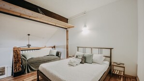 A bedroom with a wooden bed frame, a loft-style bed, and a small bedside table. - 18sll - Newly Remodeled - Sleeps 4 - Fireplace - W/d 1 Bedroom Condo by RedAwning (Deming)