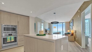 Una cocina moderna con electrodomésticos integrados, una isla central y vistas al área de estar.