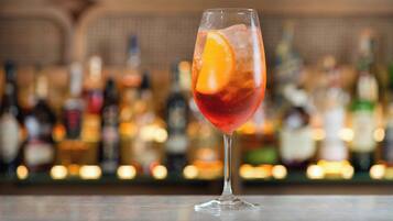 A cocktail glass with an orange slice on a bar counter.