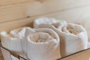 A basket containing rolled white towels.