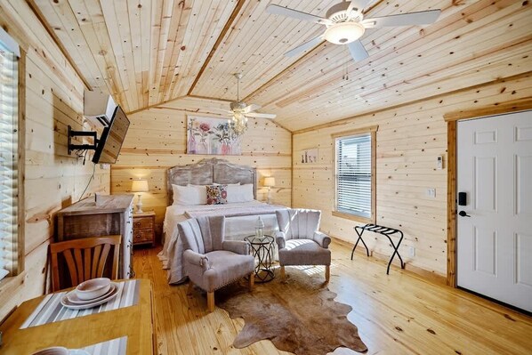 L’intérieur chaleureux d’un chalet comprend un lit, un coin salon et une table à manger.