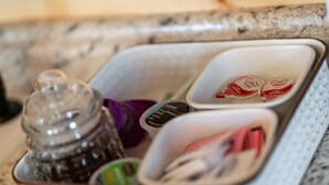 A kitchen counter with a spice rack containing various containers. - Romantic Stay Right On Main St! (Fredericksburg)