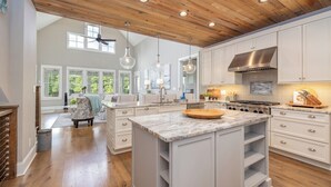 A spacious kitchen with white cabinetry, a large island, and a wooden ceiling. - The Oasis at Lake Gaston - Heated Pool, Hot Tub, Pontoon Boat Rental Included! (Littleton)