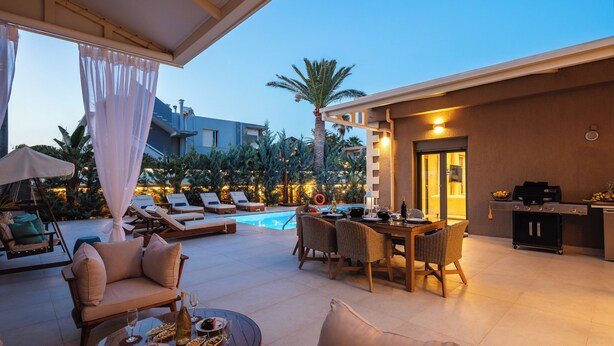 Eine Außenpatio mit Pool, Liegestühlen, einem Essbereich und Grillplatz.