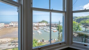 A bay view from a window with a view of boats, buildings, and a hilly landscape. - 5 Bed in Ilfracombe (oc-stagn) (Ilfracombe)