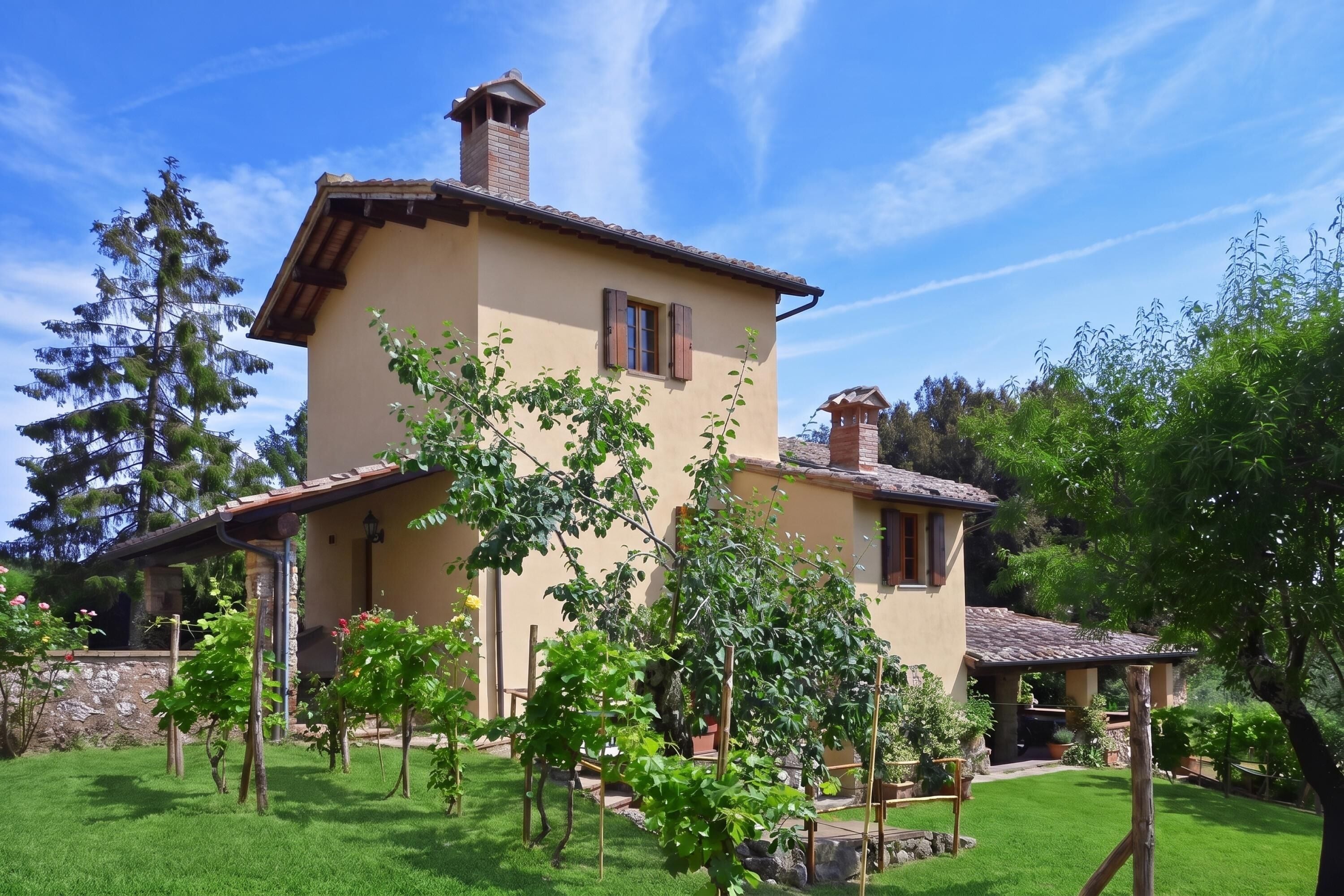 A two-story house with a tiled roof, surrounded by a well-maintained garden with various plants and a lawn.