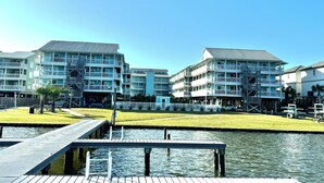 Ein Hotel am Wasserufer mit mehreren Balkonen und einer Anlegestelle, die ins Wasser ragt.