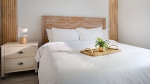 A neatly made bed with white linens, a wooden headboard, and a bedside table with a lamp and a plant. - ` The Bohemian Heaven ` w/ SPA, 2miles to downtown (Naples)