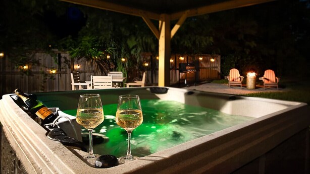 A hot tub with two glasses of wine, a grill, and outdoor seating. - ` The Bohemian Heaven ` w/ SPA, 2miles to downtown (Naples)
